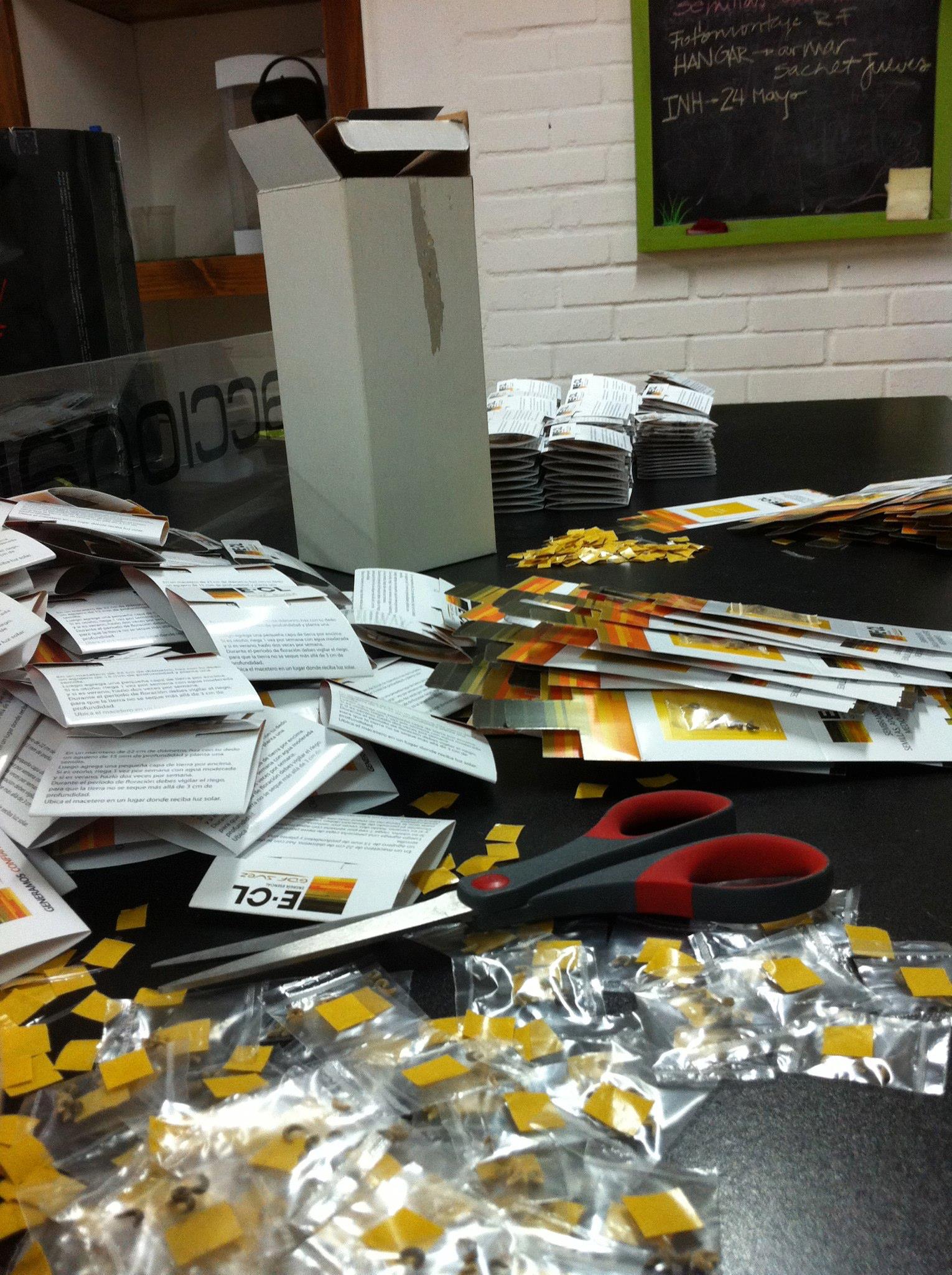Mesa de trabajo en nuestro taller, preparando sachets de semillas y material impreso
