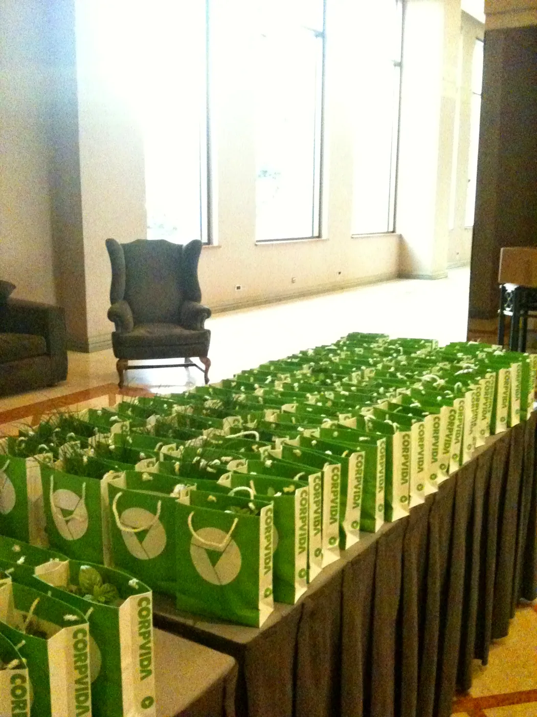 Mesa con bolsas verdes de Corpvida con plantas para entregar a los invitados